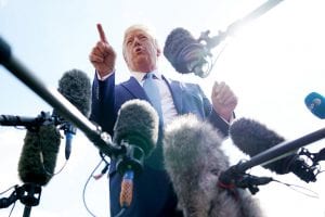 President Donald Trump speaks to reporters with microphones