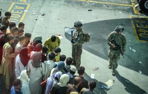 Walik Koshar/AFP/Getty Images - People waiting at Kabul airport to flee Afghanistan as U.S. soldiers stand guard.