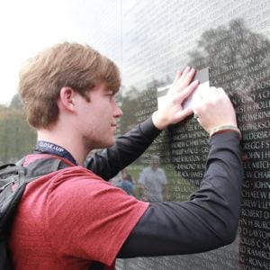 High school male student learning at Vietnam Memorial in Washington, DC