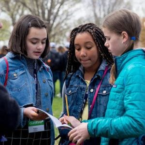 Middle school girls reading notebook on National Mall