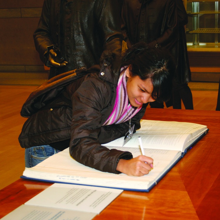 American Indian female student signing a book like founding father in Philadelphia