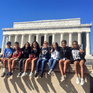 Middle school students posing on sunny day in front of Lincoln Memorial