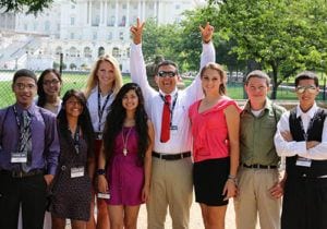Group of high school students and their teacher posing in front of the U.S. Capitol