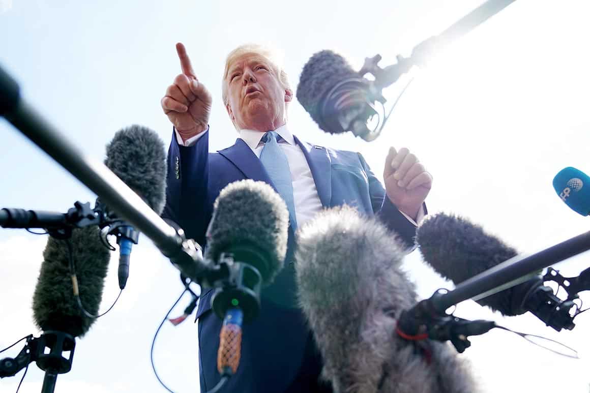 President Donald J Trump speaks to reporters with microphones